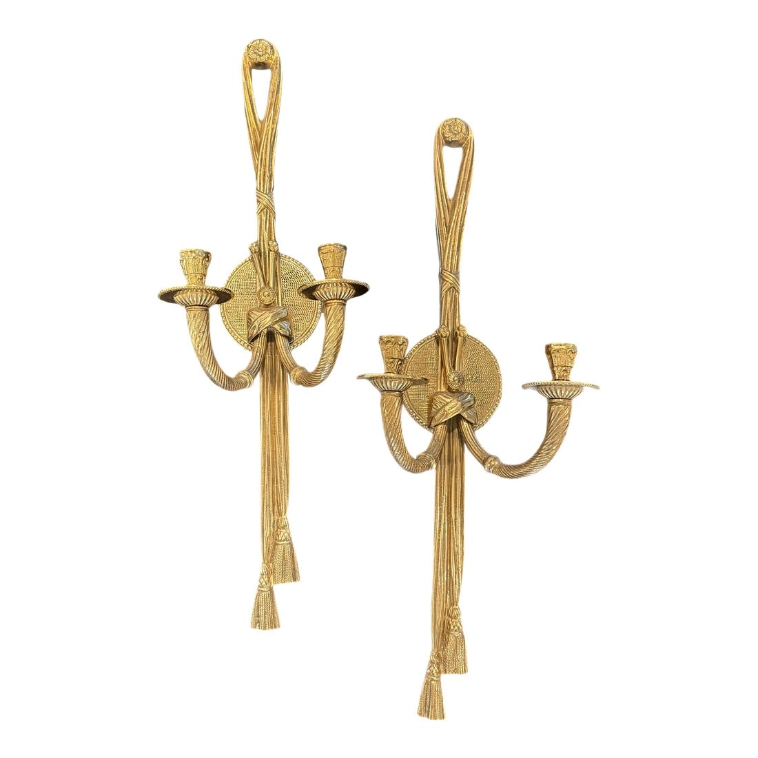 Mid 20th Century Grand Pair of Hollywood Regency Brass Tassel Wall Sconces: This refined pair of Hollywood Regency wall sconces is crafted in gilt brass with elegant neoclassical detailing, including twisted rope elements and tassel motifs. Each sconce features two curved