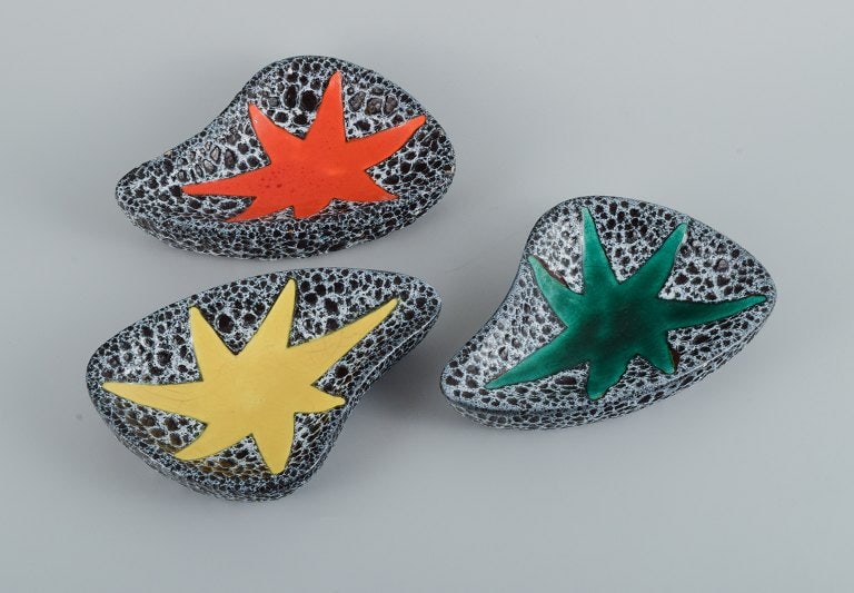 Vallauris, France, three ceramic bowls in brightly colored glazes in red, yellow and green on a dark (1 of 9)