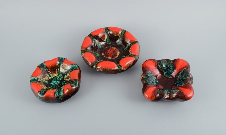 Vallauris, France, three ceramic bowls in brightly colored glazes in red and green on a dark base. (1 of 9)