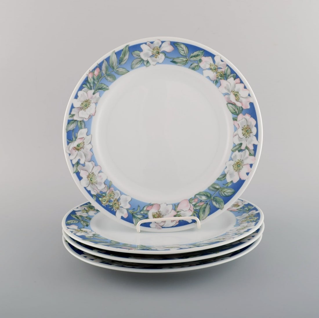 Four Royal Copenhagen White Rose dinner plates with blue border, white flowers and foliage. Dated (1 of 4)