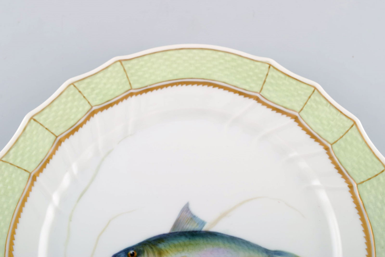 Royal Copenhagen fish plate with green edge, gold decoration and fish motif. Model 919/1710. - 2