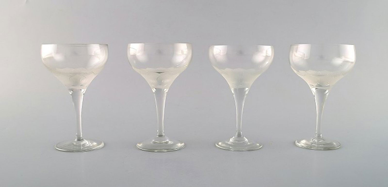 Bjørn Wiinblad (1918-2006) for Rosenthal. Four "Lotus" glasses in clear art glass decorated: Title: Bjørn Wiinblad (1918-2006) for Rosenthal. Four "Lotus" glasses in clear art glass decorated with lotus flower. 1980's. Description: Bjørn Wiinblad (1918-2006) for Rosenthal. Four