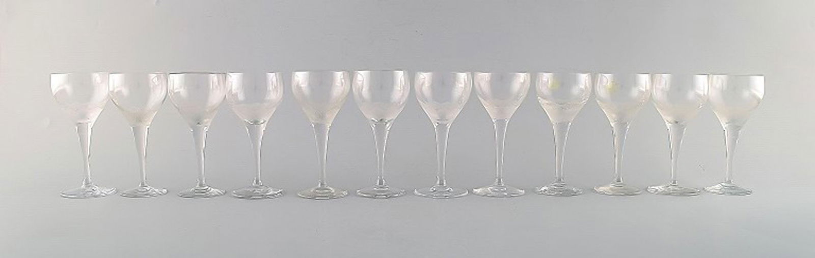 Bjørn Wiinblad (1918-2006) for Rosenthal. Twelve "Lotus" glasses in clear art glass decorated: Title: Bjørn Wiinblad (1918-2006) for Rosenthal. Twelve "Lotus" glasses in clear art glass decorated with lotus flower. 1980's. Description: Bjørn Wiinblad (1918-2006) for Rosenthal. Twelve