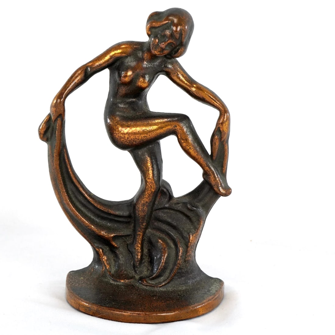 Art Deco Woman Dancer Single Bookend: Title:Art Deco Woman Dancer Single Bookend Size:6 3/8 in (16.1 cm) tall x 4 1/4 in (17.8 cm) wide x 2 1/2 in (6.4 cm) deep. Description:A sculptural bronze-colored bookend with an Art Deco design of a