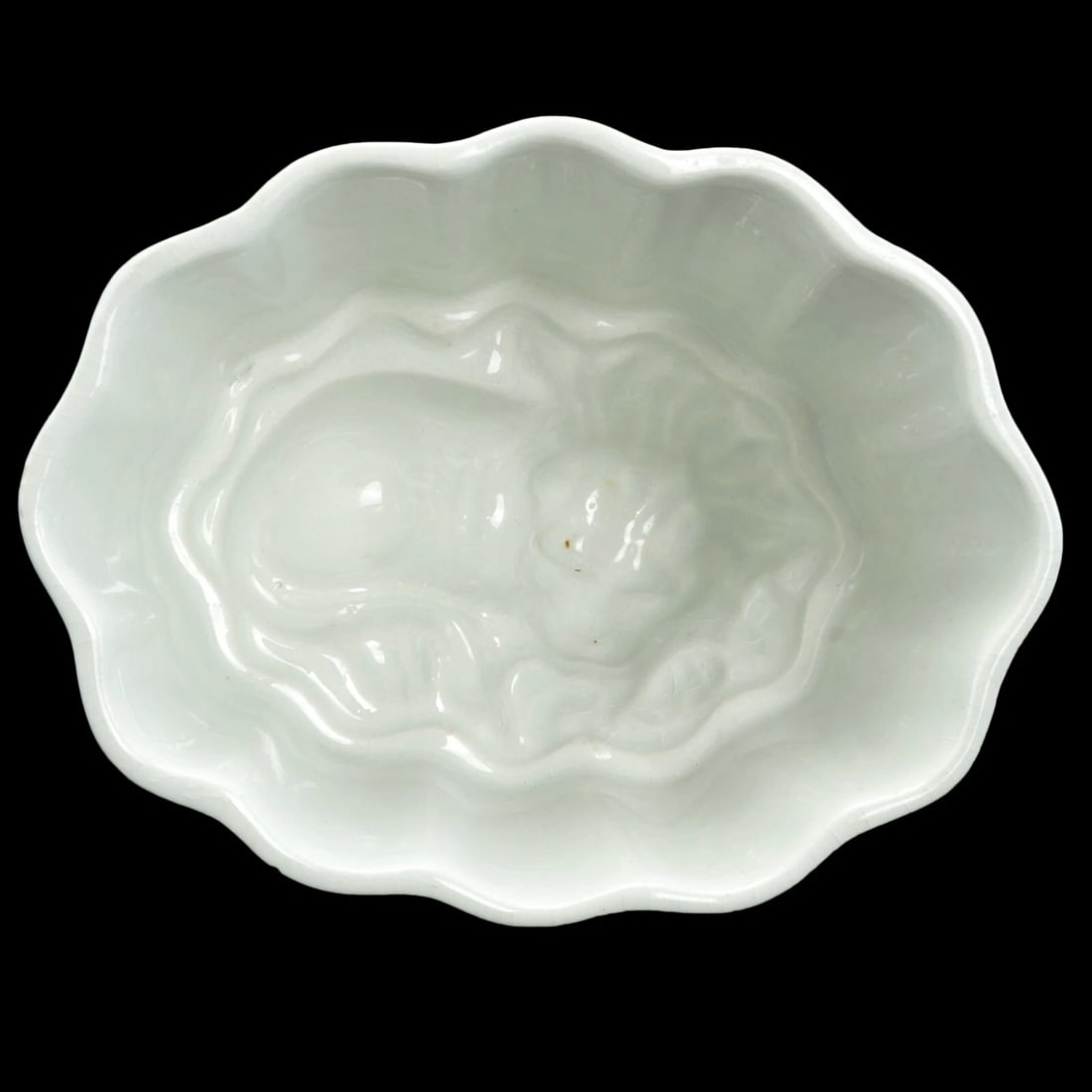 Victorian Small Food Mold with Lion Design: Title:Victorian Small Food Mold with Lion DesignSize:4 7/8 in (12.4 cm) long x 3 3/4 in (9.5 cm) wide x 3 3/8 in (8.4 cm) tall.Description:A small fluted white food mold with a design of a lion in