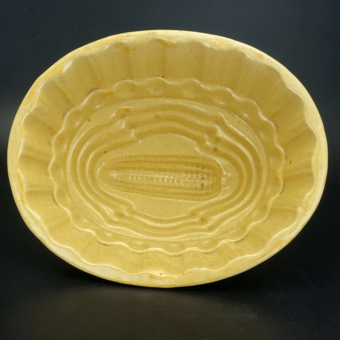Victorian Large Food Mold Corn Design: Title:Victorian Large Food Mold Corn Design Size:9 in (22.9 cm) long x 7 1/2 in (19.0 cm) wide x 3 7/8 in (9.8 cm) tall. Description:A large deep ceramic yellow ware food mold with ornate moldings and