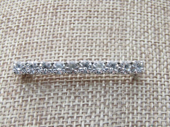 Vintage Rhinestone Bar Brooch, 1-5/8" long, 4mm Tall: DescriptionVintage Rhinestone Bar Brooch, 1-5/8" long, 4mm tall, ten clear and bright rhinestones that are appx. 4mm across. Silver tone setting, not signed by the maker. Very good condition. 1970's-1