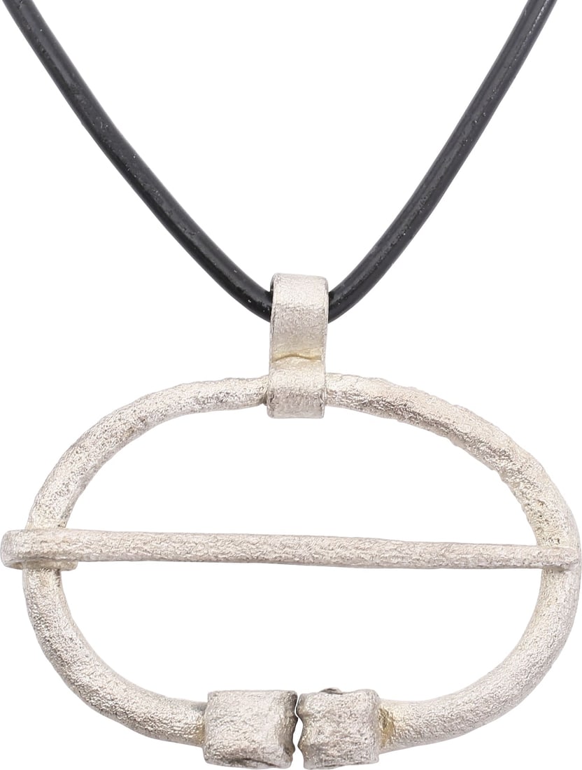 ANCIENT VIKING PROTECTIVE BROOCH 850-1050 AD: Just under 1 5/8" width, oval form with the ends deeply reeded and curled. Original cross pin. Worn in numbers on the leather war jerkin, at an ounce each, a few pounds could be added providing signif