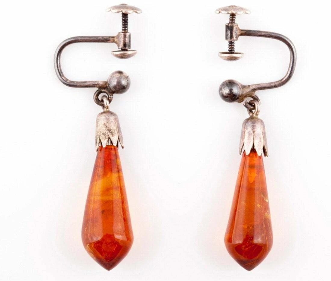 Sterling Silver Carved Amber Dangle Earrings: Title:Sterling Silver Carved Amber Dangle EarringsDescription:Sterling silver with amber dangle earrings. Circa 1940’s to 1950’s. Earrings measure 22 mm’s by 7 mm’s. Total weight