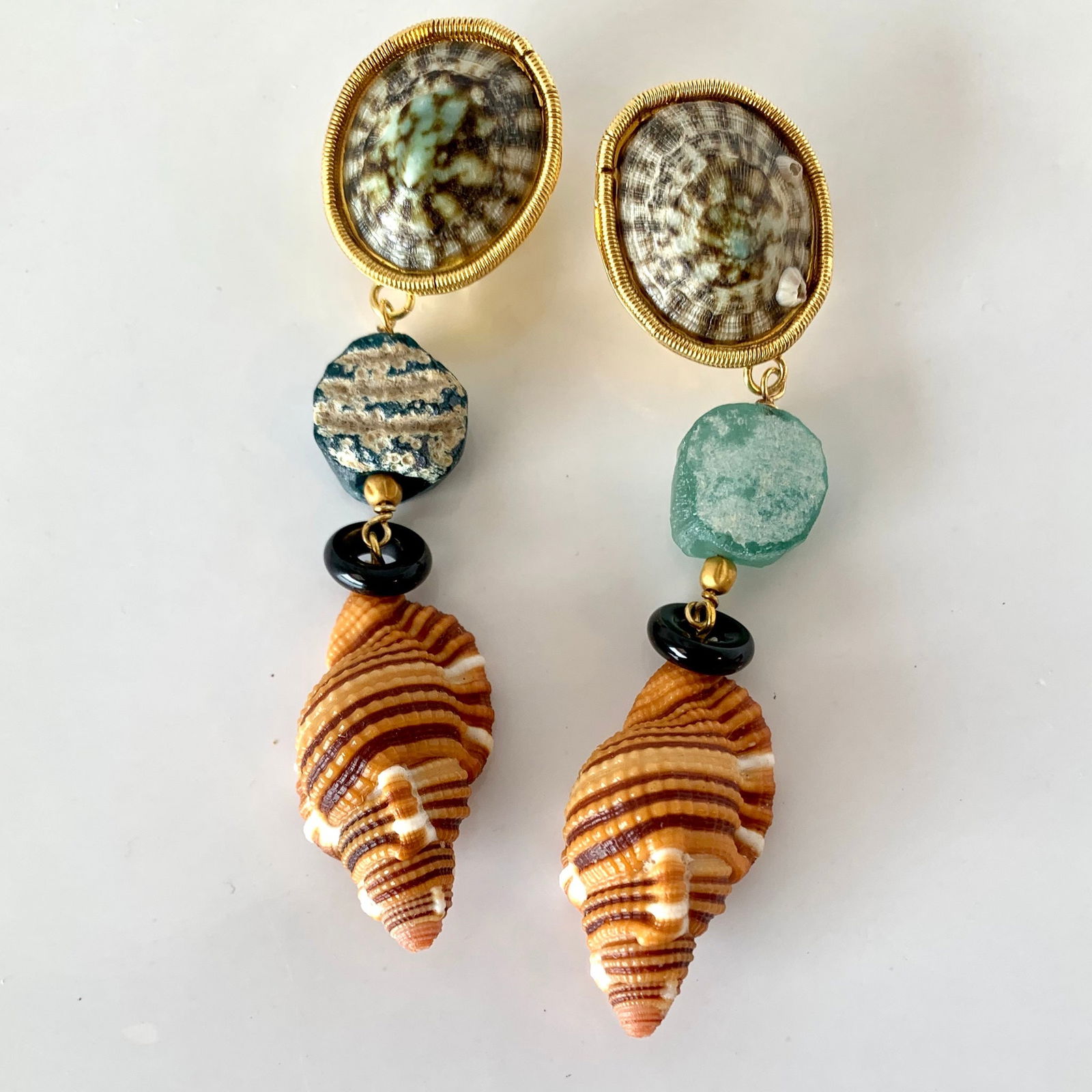 Rustic Roman Glass, Onyx, Cymbatium Vermeil Earrings: Title:Rustic Roman Glass, Onyx, Cymbatium Vermeil EarringsDescription:Comfortable every day Omega Clip pierced earrings made of Blue Limpets, ancient Roman Glass, 18th c., 18-karat Gold beads, Onyx