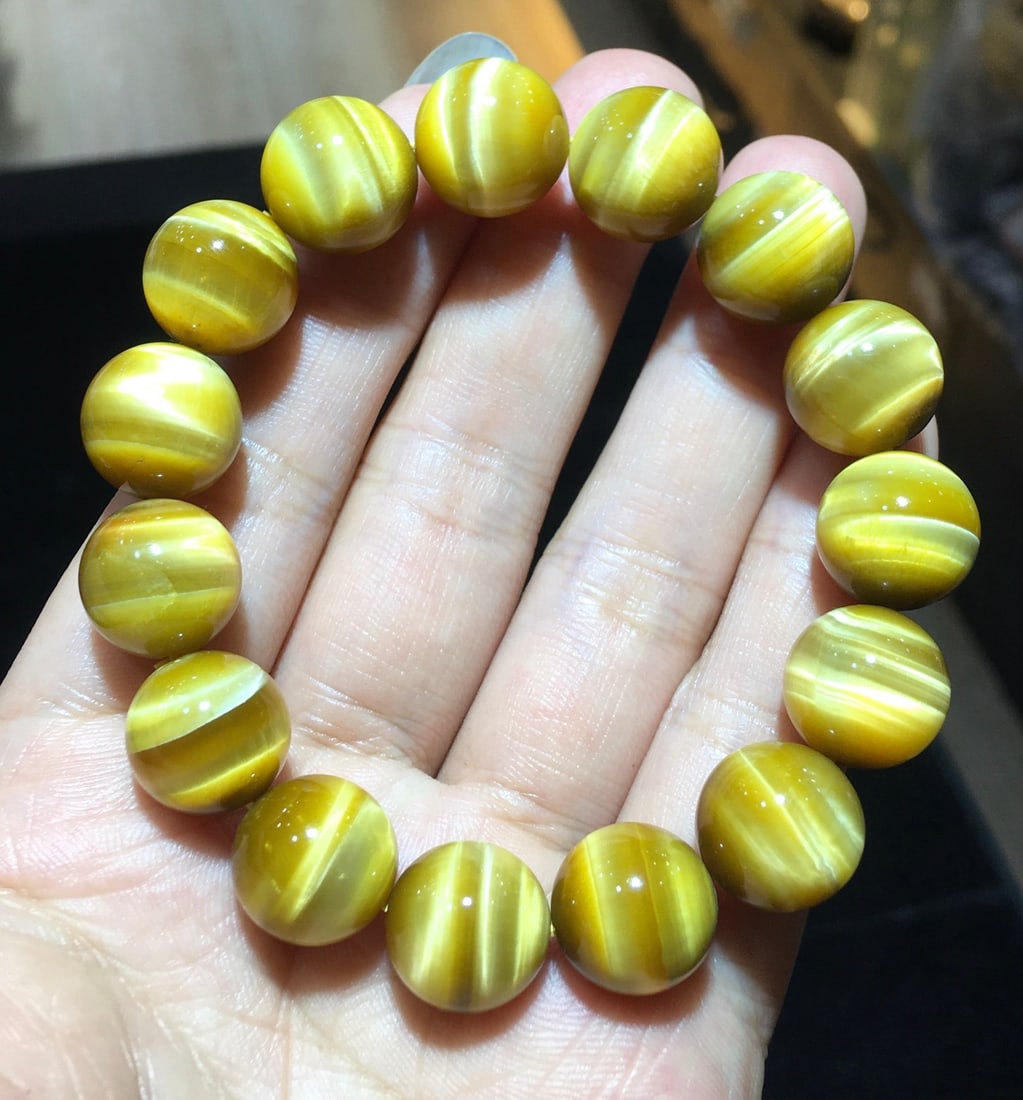 Tiger Eye Bracelet: Title: Tiger Eye Bracelet Description: This bracelet showcases the captivating charm of 14mm tiger eye stones, known for their rich, glossy texture. The intricate patterns of the stones are not only