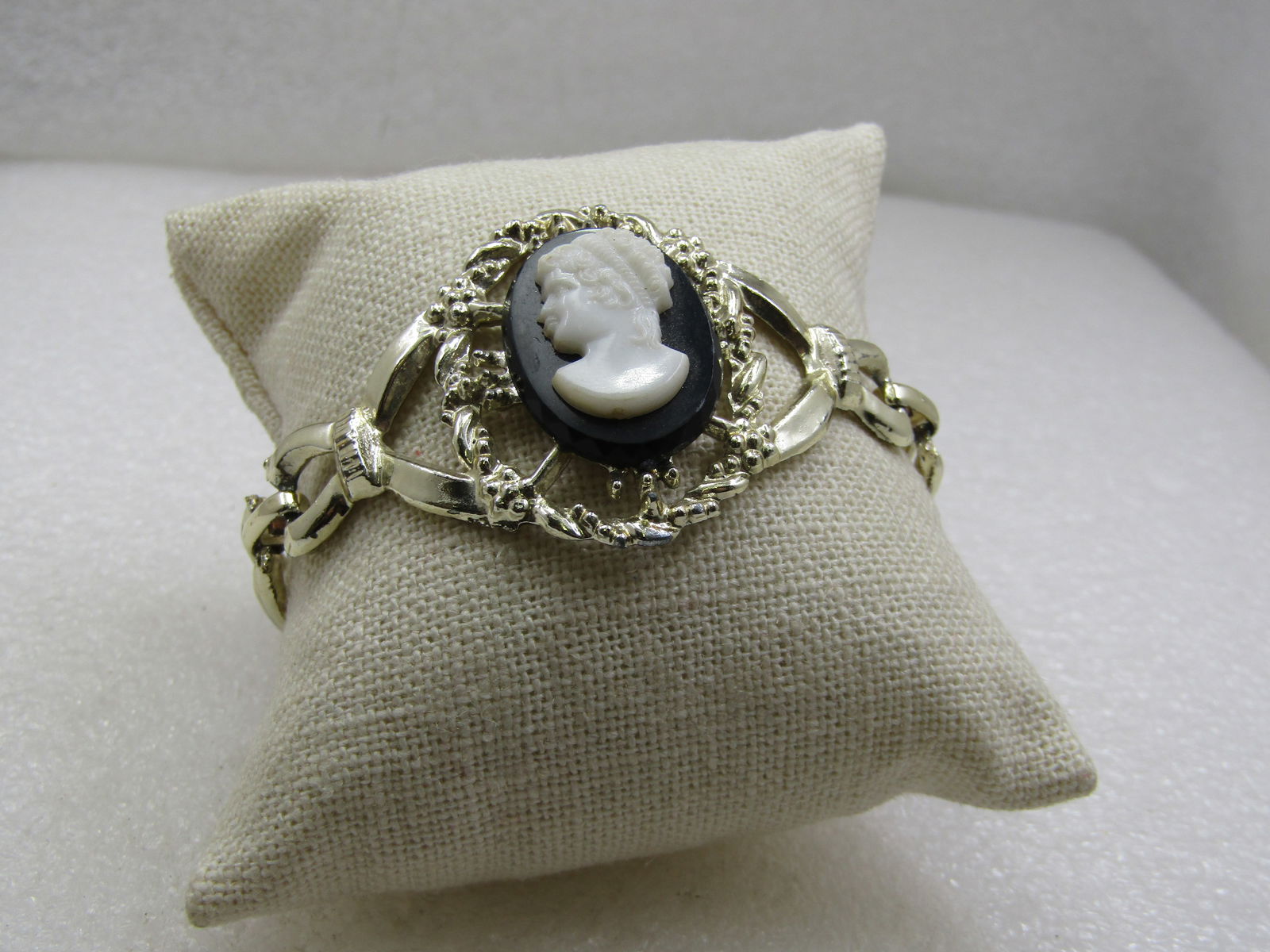 Vintage Black & White Cameo Bracelet, Gold tone, 7", 1960's: Title: Vintage Black & White Cameo Bracelet, Gold tone, 7", 1960's Description: Vintage Black & White Cameo Bracelet, Gold tone, 7", 1960's,. It is 1.5" wide at the center of the wring and tapered aro