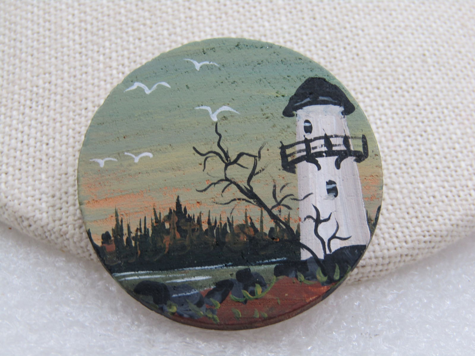 Vintage Hand Painted Lighthouse Brooch on Wood, 1.5": Title: Vintage Hand Painted Lighthouse Brooch on Wood, 1.5" Description: Vintage Hand Painted Lighthouse Brooch on Wood, 1.5" round with a white and black lighthouse overloking water and trees in the