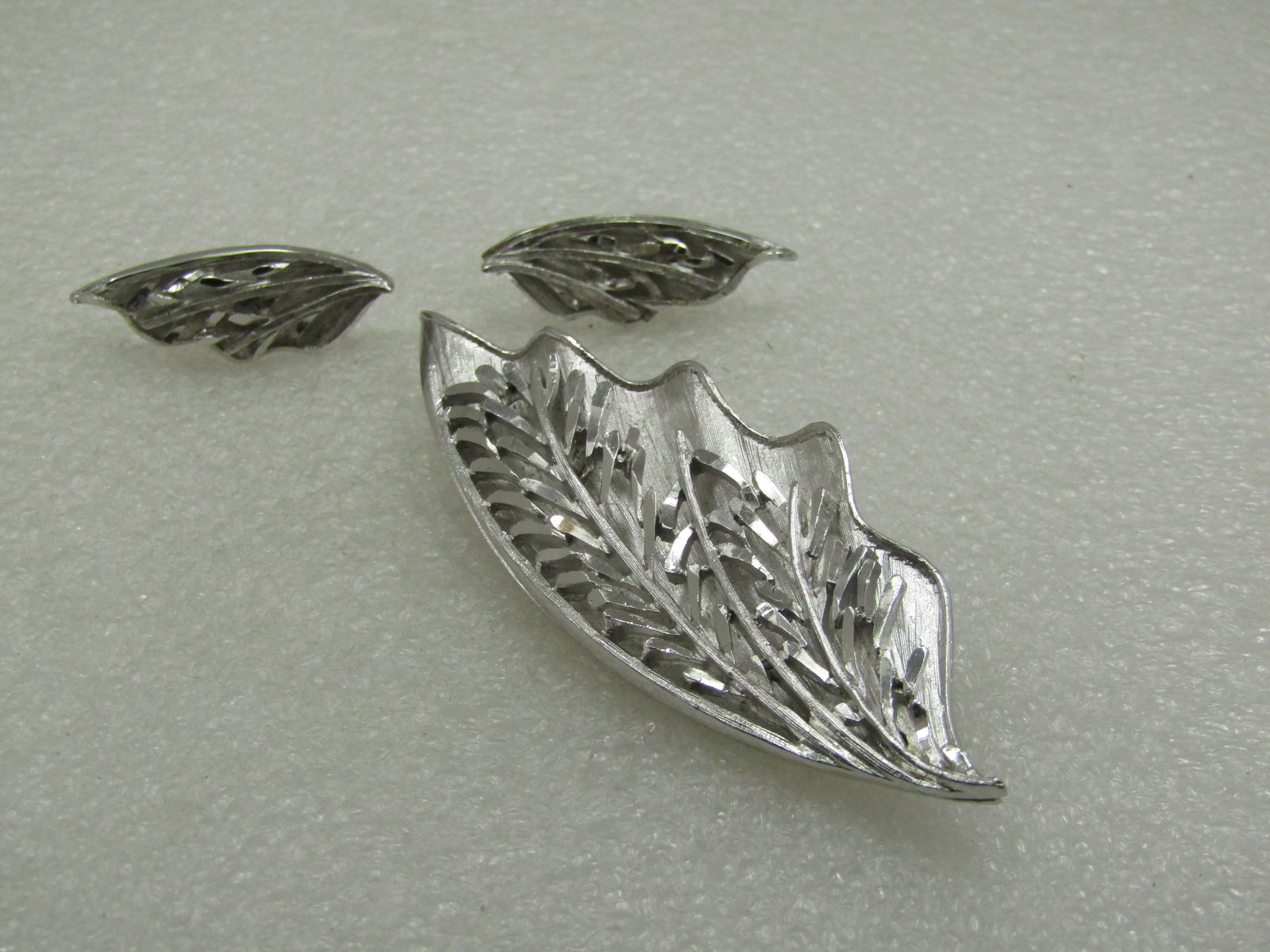 Vintage Coro Leaf Brooch & Clip Earrings Set, Tiered, 1960's: Title: Vintage Coro Leaf Brooch & Clip Earrings Set, Tiered, 1960's Description: Vintage Coro Leaf Brooch & Clip Earrings Set, Tiered, 1960's. Silver tone with a wavy bottom layer that is larger than