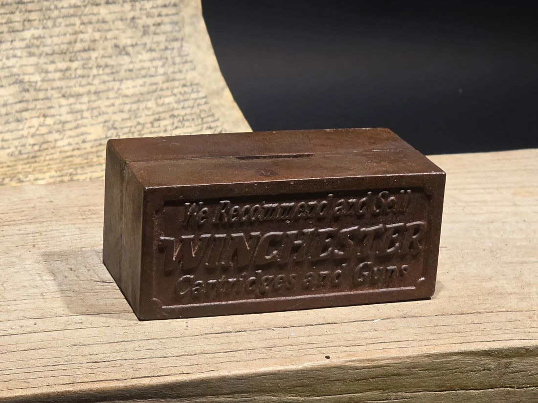 Vintage Cast Iron Winchester Coin Bank: Title:Vintage Cast Iron Winchester Coin BankDescription:4 3/8" long x 1 7/8" Tall A wonderful reproduction cast iron collectible advertising Winchester coin bank. Advertising pieces like this many