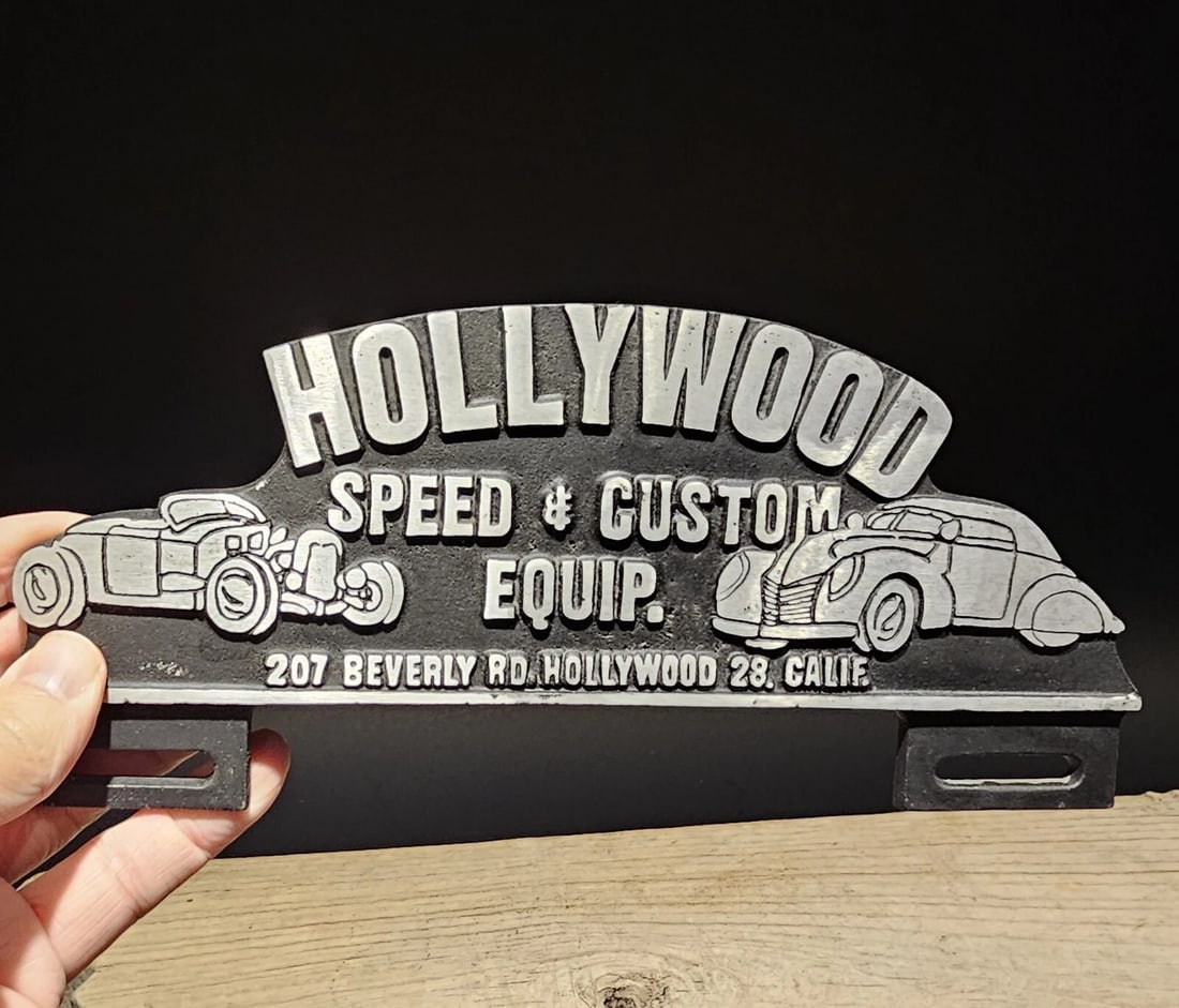 Aluminum Holywood License Plate Fob Topper: Title:Aluminum Holywood License Plate Fob TopperDescription:9 3/4" Wide x 4 1/4" Tall Wonderful reproduction license plate topper. Good detail aluminum, slightly aged to look like an antique.