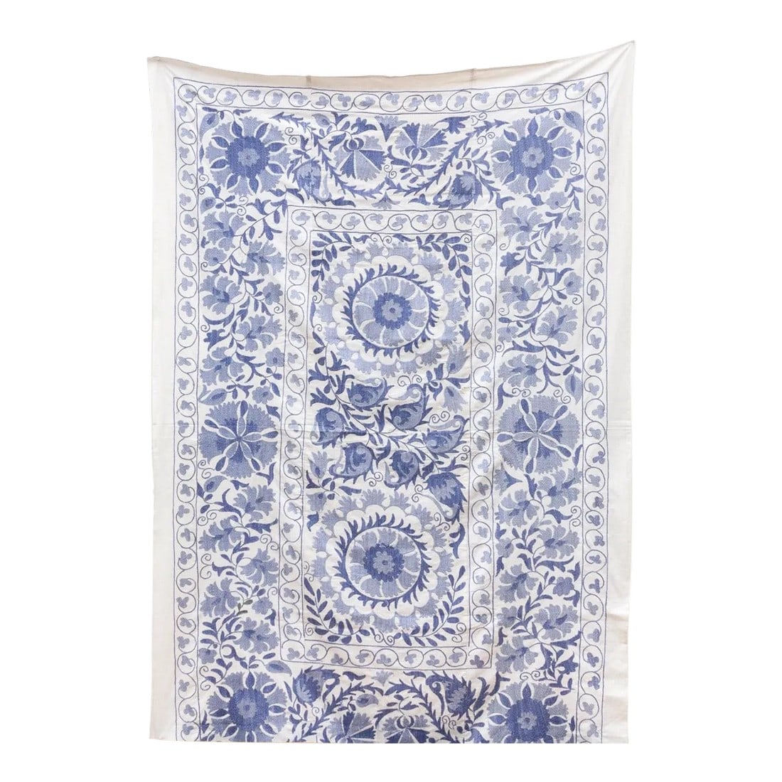 Blue Blossom Uzbek Suzani Throw: This large vibrant Suzani tapestry was handcrafted in Uzbekistan. The soft, off-white cotton background provides a canvas for a captivating display of hand-embroidered floral motifs. Lush blue thread