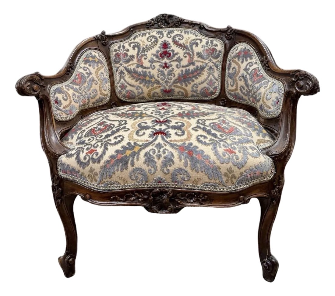 Early 20th Century Petite Needlepoint Bergère Chair With Intricately Carved Walnut Frame: Early 20th Century petite bergère chair with silver-grey needlepoint upholstery, deep red and gold accents and matching brocade trim. The dark walnut frame is highly carved and is a beautiful
