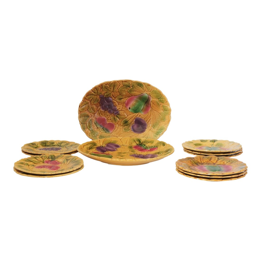 Early 1900s French Sarreguemines Majolica Fruit Serving Set: This radiant French majolica fruit service by Sarreguemines is pure table theatre. Featuring two platters and ten plates, each piece is richly molded with sculptural fruit and foliage"”grapes,