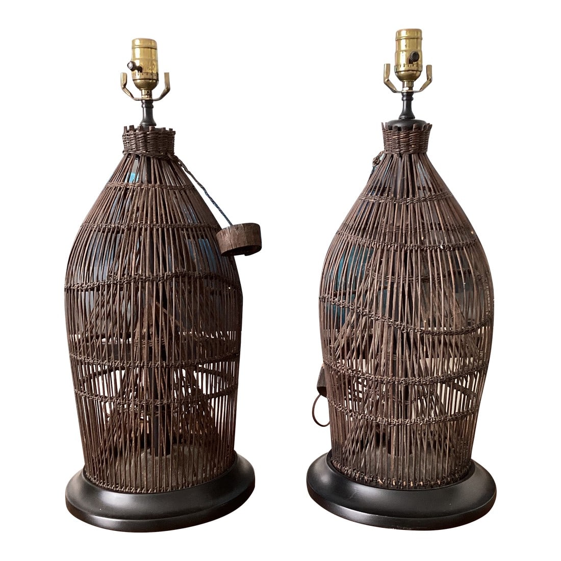 1960s Handwoven Wicker / Rattan Basket Lamps on Ebonized Bases - a Pair: Striking pair of sculptural table lamps crafted from handwoven wicker or rattan in a basket-form silhouette. The organic, tapered bodies showcase beautiful natural variation in the weaving, lending