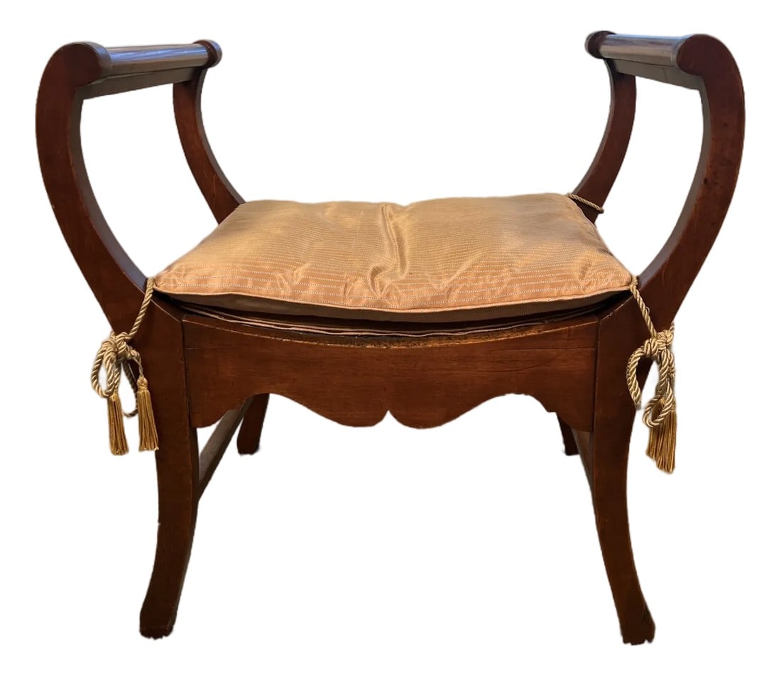 Late 20th Century Empire Revival Mahogany Side Bench With Striped Cushion and Tassel Ties: An elegant Empire Revival side bench featuring gracefully scrolled ends, saber-style legs, and a warm mahogany finish. The bench is topped with a tailored champagne-toned striped cushion, finished