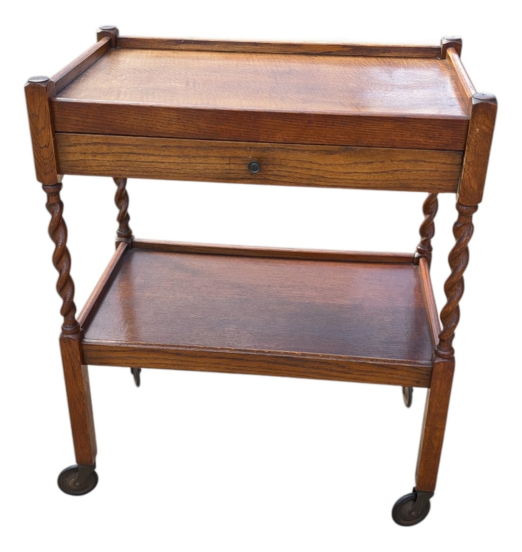 Antique Edwardian Oak Barley Twist Tea Cart: This antique tea cart features a two-tiered design with a single drawer and original casters. Excellent period condition, some minor wear from where someone set a plant on it once, that can only