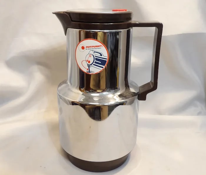 Zimmermann Coffee Thermos Jug: Sleek Zimmermann coffee thermos jug in a polished metal finish, featuring a thermal lining to keep beverages hot. Shipping:Domestic: Flat-rate of $20.00 to anywhere within the contiguous