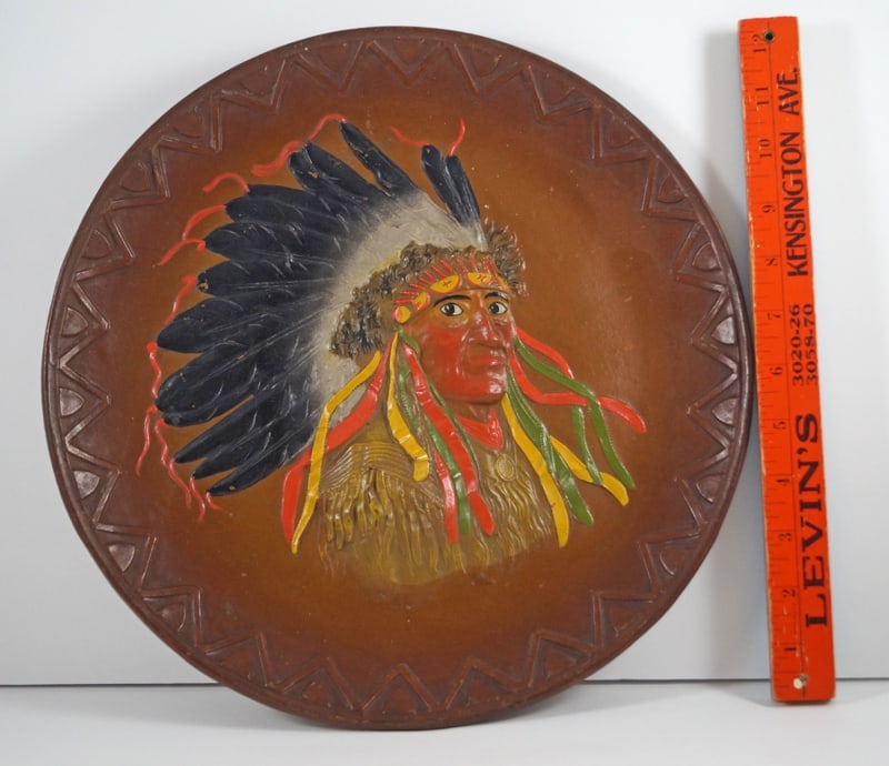 Antique Native American Indian Cast Iron Plaque: Title: Antique Native American Indian Cast Iron PlaqueDimension: 12 ¾” diameter x 1 3/8” deep.Date: Circa 1920’s.Additional Information: Outstanding figural cast iron Antique