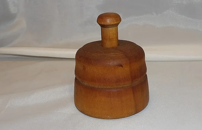 Antique Small Wooden Floral Pattern Butter Mold: A charming antique wooden butter mold featuring a hand-carved floral pattern, used to press decorative designs into butter. Shipping:Domestic: Flat-rate of $15.00 to anywhere within the contiguous