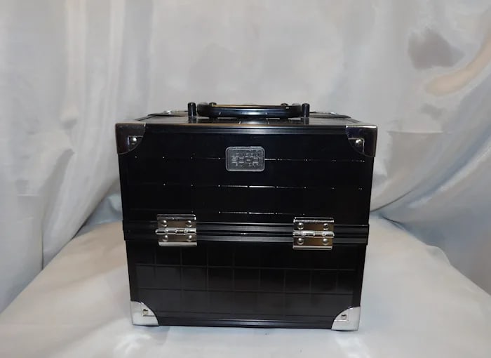 Soho Black Top Handle Cosmetic Makeup Bag: Sleek black Soho cosmetic bag with a sturdy top handle, zippered closure, and spacious interior for makeup storage. Shipping:Domestic: Flat-rate of $20.00 to anywhere within the contiguous