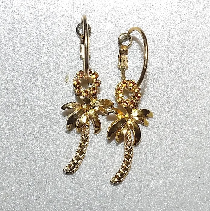 Palm Tree Gold Tone Brooch: Charming vintage gold-tone brooch shaped like a palm tree, featuring textured details on the fronds and trunk. Shipping:Domestic: Flat-rate of $11.00 to anywhere within the contiguous