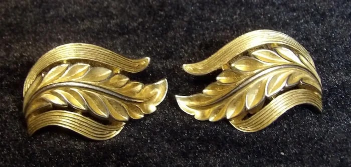 Mid-Century Trifari Gold-Tone Leaf Pin: Elegant mid-century modern Trifari brooch in a brushed gold-tone leaf motif. Shipping:Domestic: Flat-rate of $11.00 to anywhere within the contiguous U.S.International: Foreign shipping rates are