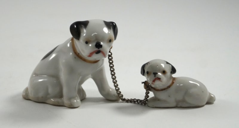 Vintage Pug Dogs Ceramic Figurines: Title: Vintage Pug Dogs Ceramic FigurinesDimension: Larger Pug – 2” tall x 2 ¾” long Lying down Pug – 1 1/8” tall x 1 ¾” lon4Date: Ca.