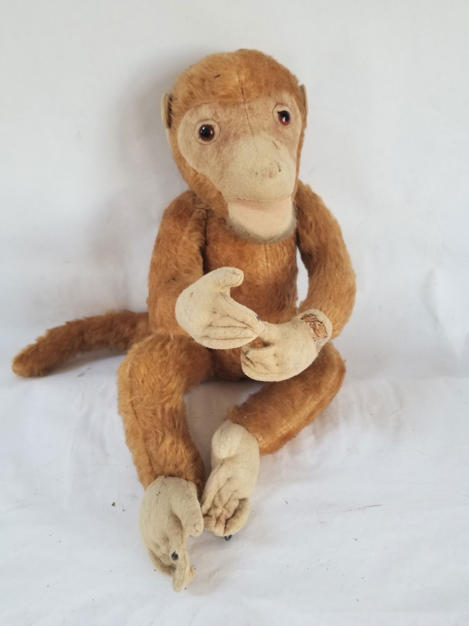 Wonderful straw-stuffed monkey: No button but he's German. 16" long. Wear on feet and hands, as shown. Head arms legs jointed. Shipping:Domestic: Shipping rates are determined by