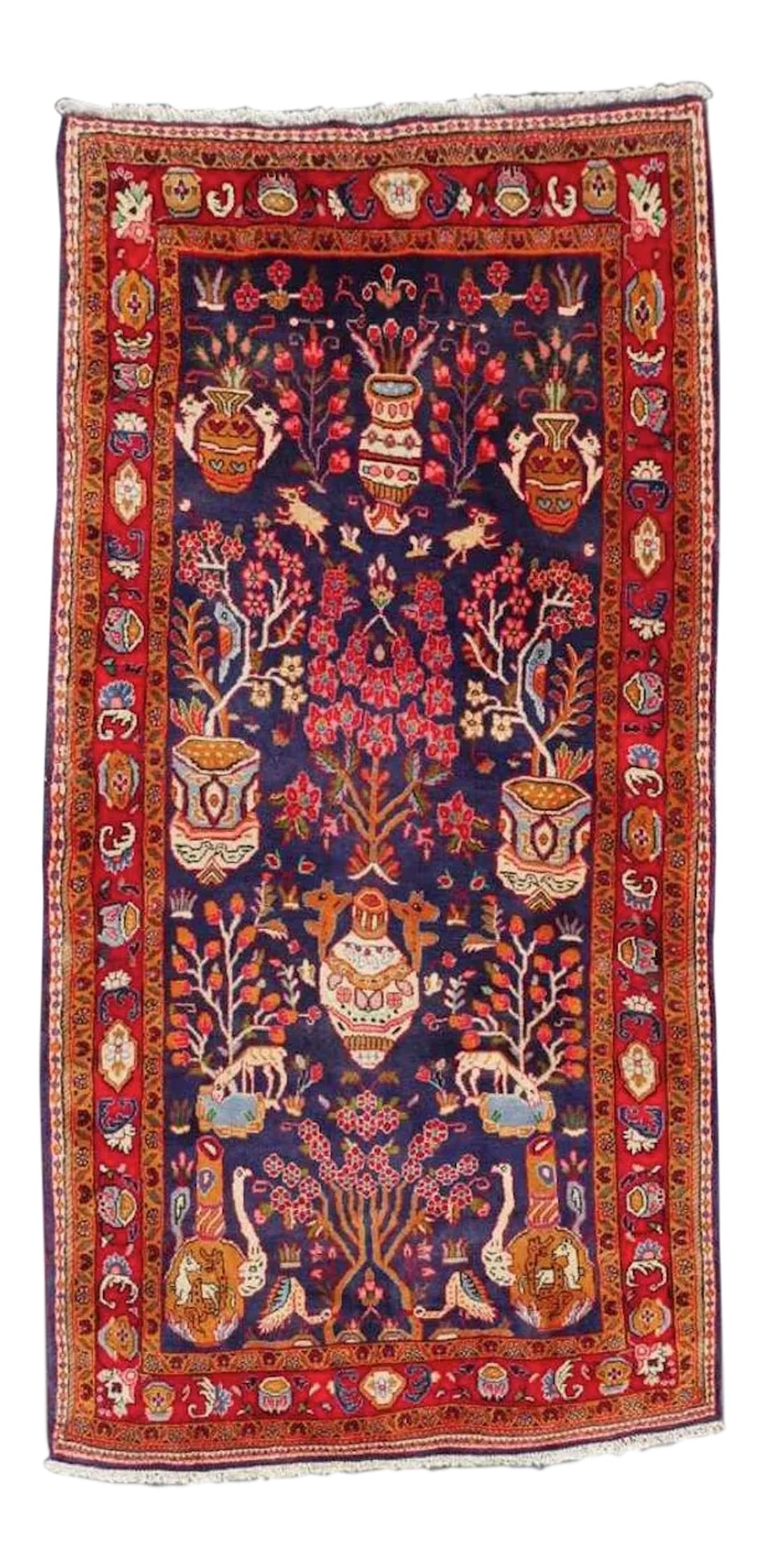 Hand-Knotted Wool Village Rug - 5' × 9': This vibrant red and blue hand knotted wool village rug has a whimsical design combining a formal vase motif with birds and animals. Deep, rich colors make it a real standout. 5' x 9' 7" Newly