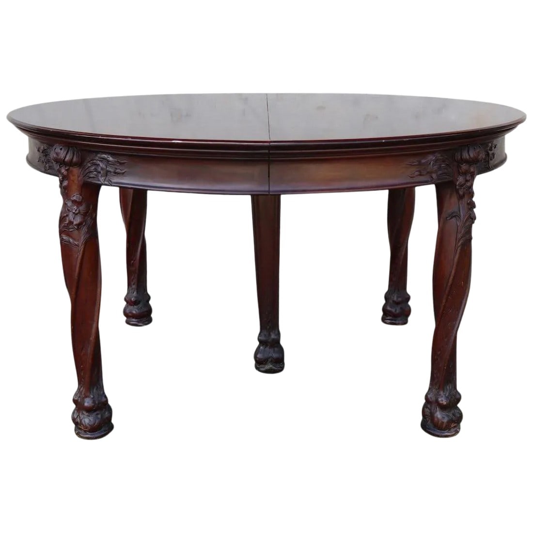 Art Nouveau Round Banquet Dining Table After Majorelle: Impressive round dining table with stylized carved legs having flowers and naturalistic foliate decorative motif. The carving, and quality is reminiscent of the French master Louis Majorelle. This