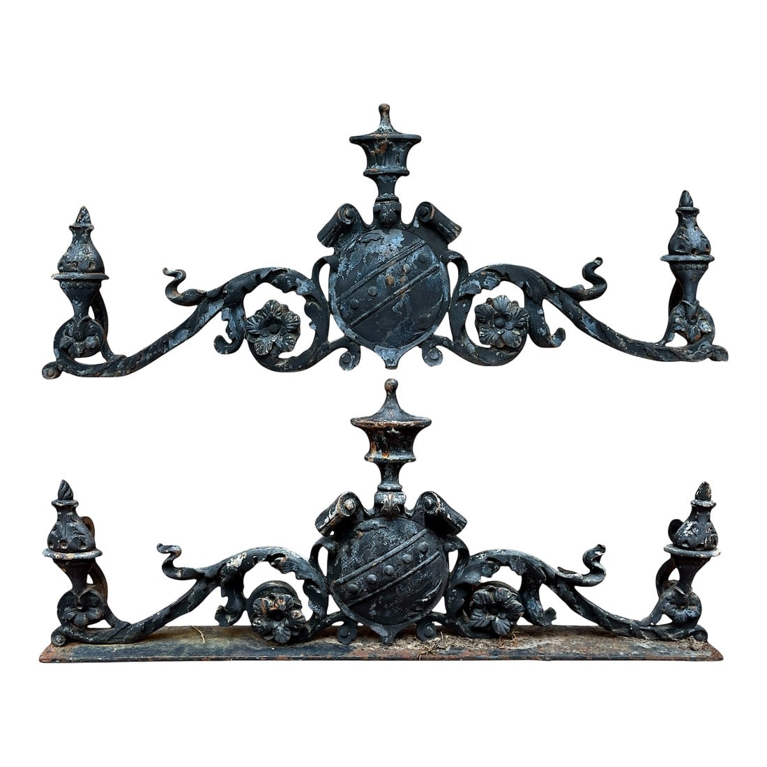 Pair of Antique Cast Iron Architectural Remnant Fragments With Heraldic Crest Motif "” 19th: A magnificent pair of antique cast iron architectural remnants, each featuring a central heraldic shield flanked by scrolling acanthus leaves, floral rosettes, and flaming urn finials. The pieces