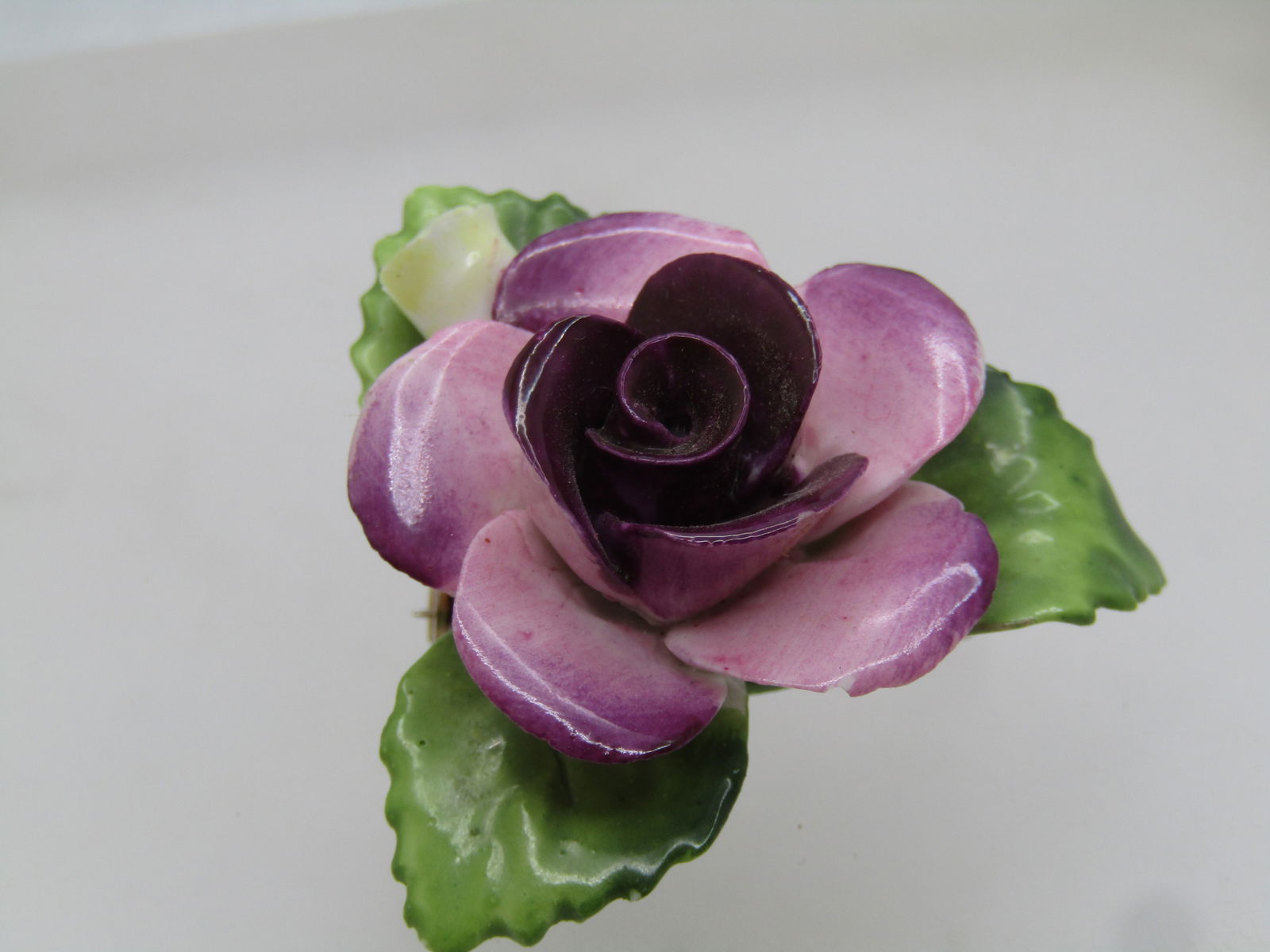 Vintage Porcelain Rose Brooch, England, 1960's, 1.75", Signed: Vintage Porcelain Rose Brooch, England, signed Cara China, 1960's, 1.75". Staffordshire England. Pink to purple rose with three green leaves arranged in a triangular pattern with a single yellow