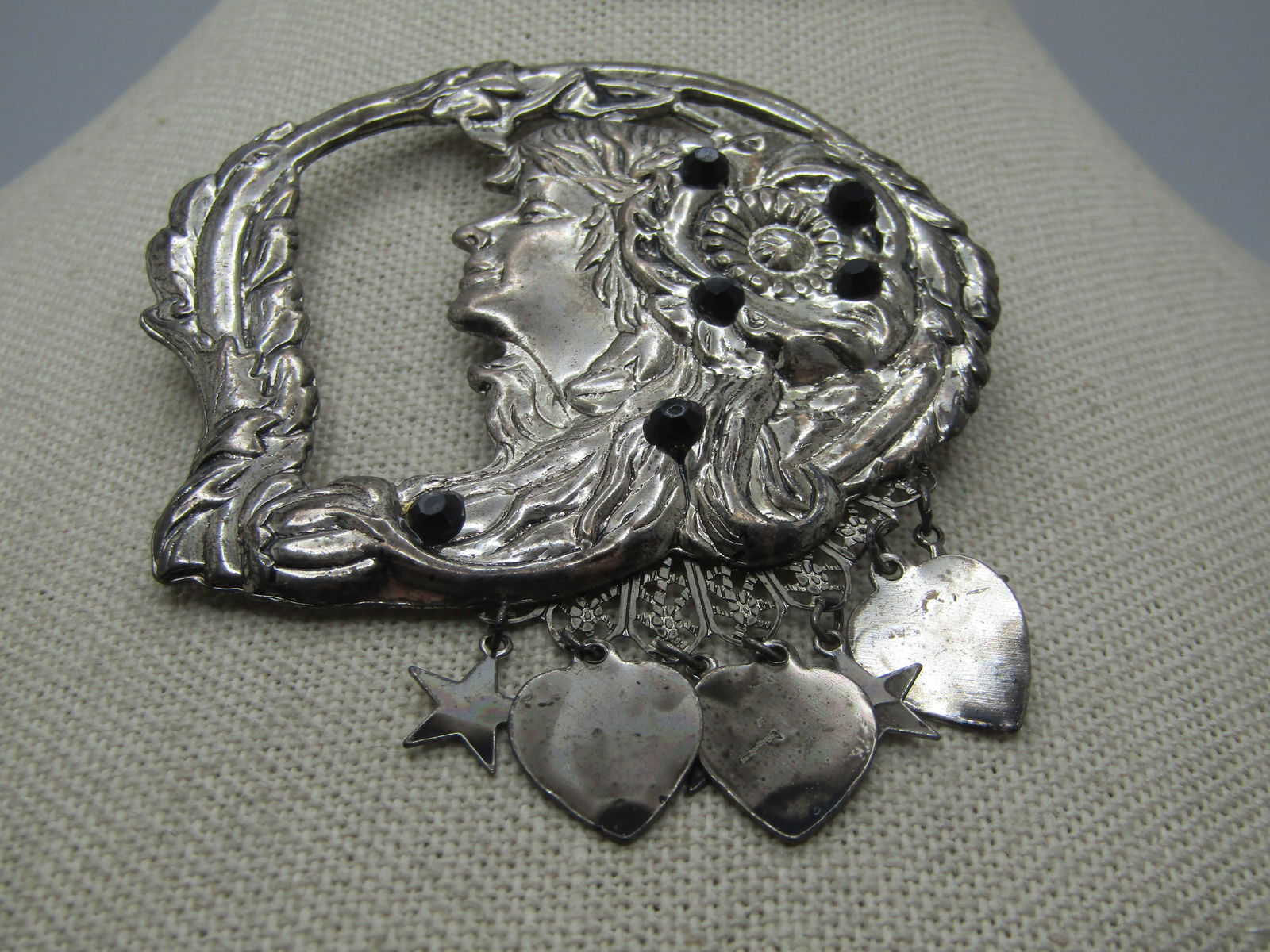 Vintage Person Floral Rhinestone Framed Brooch with Dangling Hearts and Stars: Vintage Person in Floral Rhinestone Framed Brooch with Dangling Hearts and Stars, 1980's. Pressed silver tone metal with a face - could be a woman or man with a stwig-like frame around the face and so