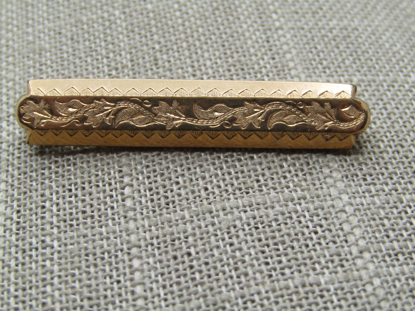 Vintage 10kt GF Bar Brooch Engraved, 1800's, C-Clasp: Vintage 10kt GF Bar Brooch Engraved, 1800's, C-Clasp. 10kt gold filled engraved/eschucheon design on top with angled front and back with a jagged design and flat on top with a floral scrolled