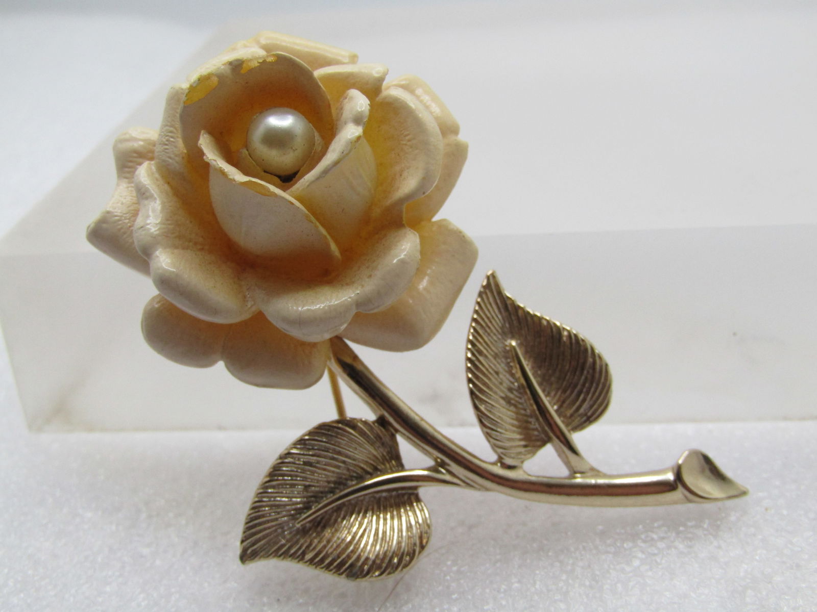Vintage White Rose Faux Pearl Brooch, Sarah Coventry, 1950's: Vintage White Rose Faux Pearl Brooch, Sarah Coventry, 1950's. Gold tone smooth stem with textured leaves and a large off white faux carved rose blossom with a center appx. 6mm faux pearl. The brooch i