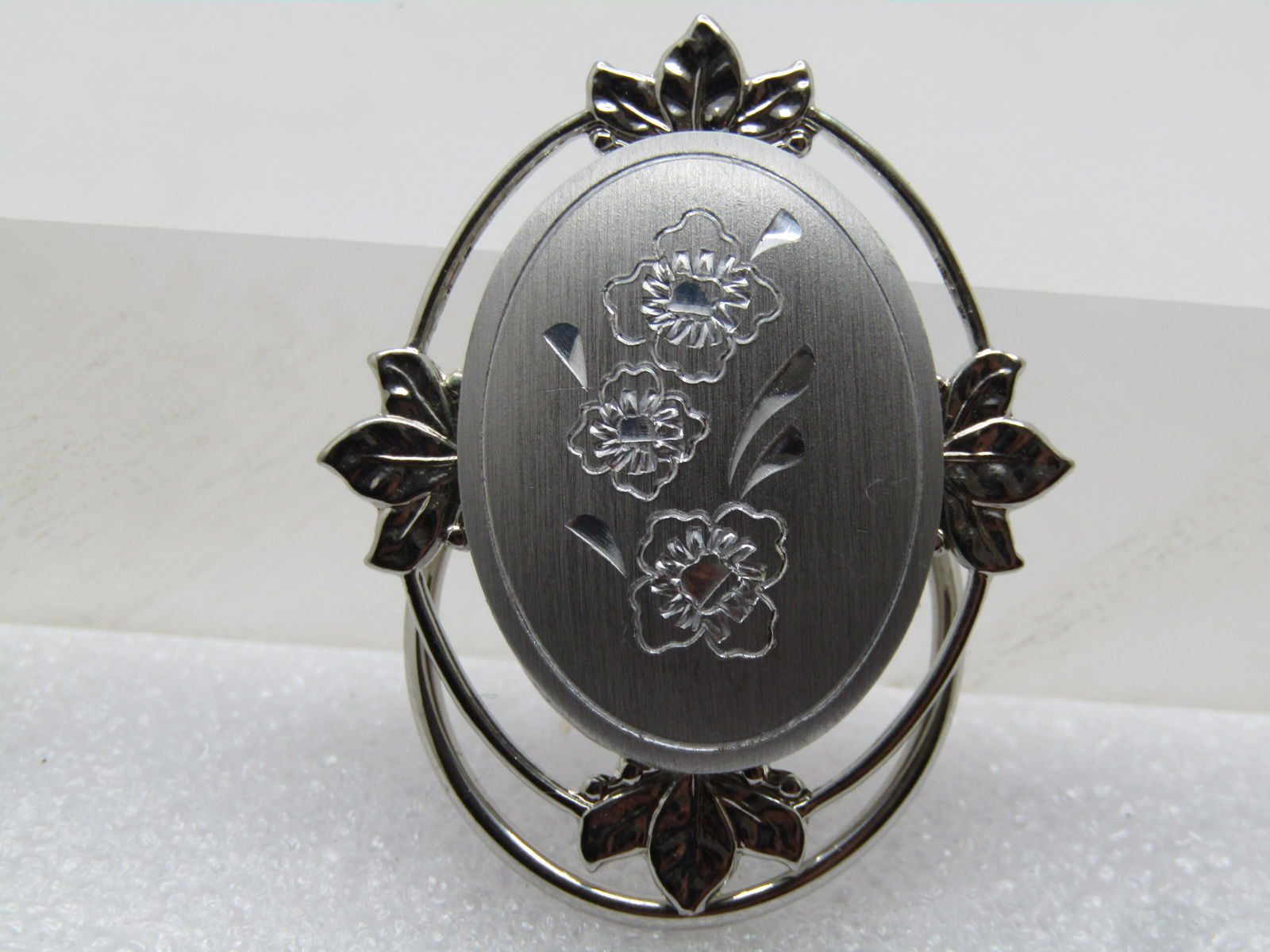 Vintage Engraved Floral Scarf Clip, Signed Jeri-Lou, 1970's-1980's: Vintage Engraved Floral Scarf Clip, Signed Jeri-Lou, 1970's-1980's. Brusted & Smooth and shiny silver tone design with the top being a brushed oval with engraved blossoms with diamond-cut accents. 