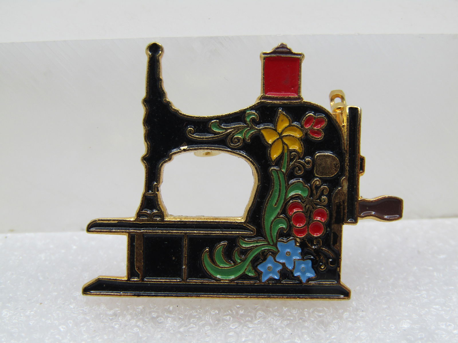 Vintage Enameled Antique Sewing Machine Brooch, 20 years, Signed: Vintage Enameled Antique Sewing Machine Brooch, 1990's, Signed Clotilde, 1971-1991. Antique style sewing machine enameled in black with red thread and flowers, green leaves and also blue and yellow
