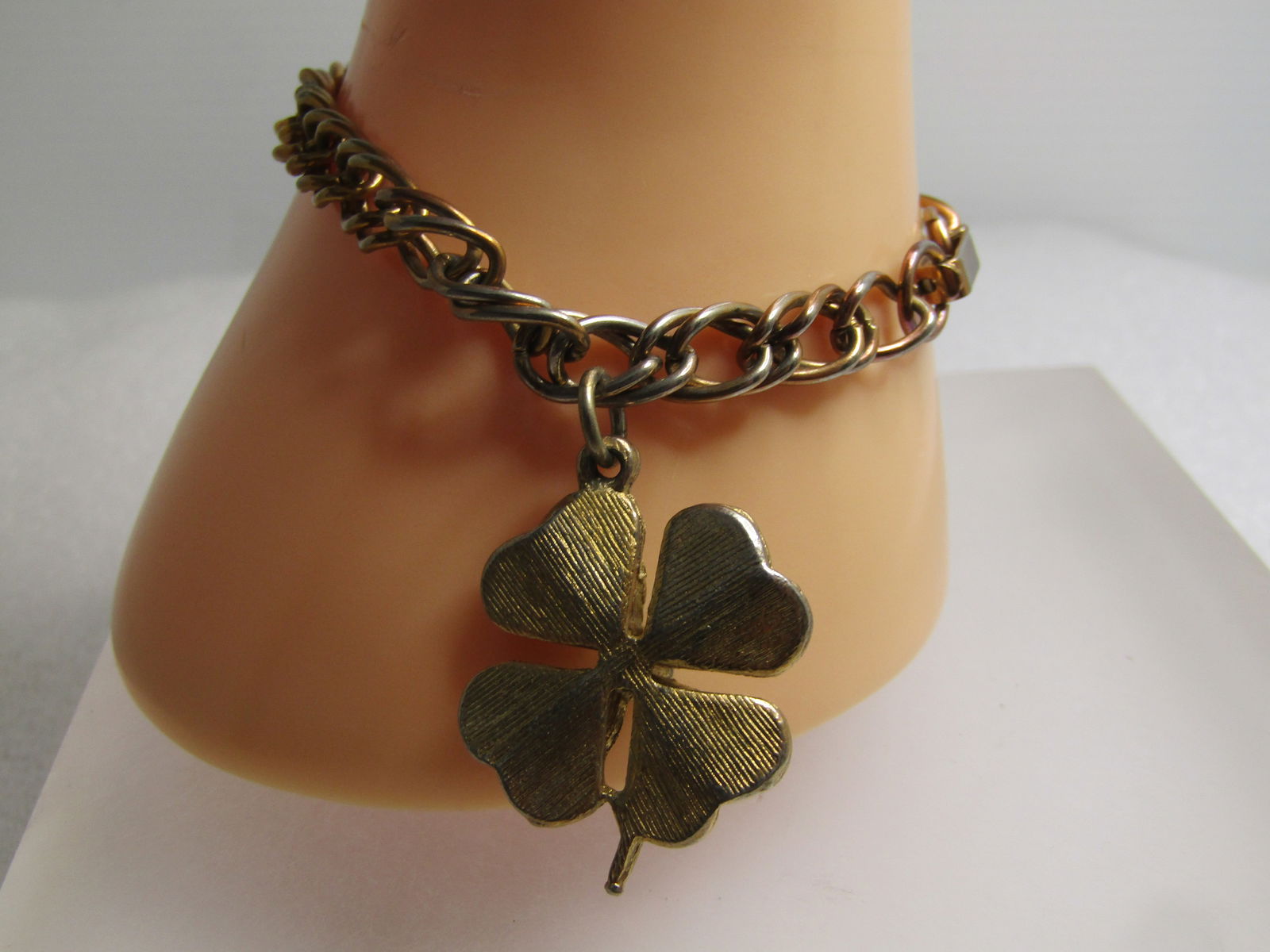 Vintage Green Rhinestone Shamrock Bracelet, 7.25", 1960's: Vintage Green Rhinestone Shamrock Bracelet, 7.25", 1960's. Gold tone with a 6.5mm wide chain. Hanging appx. 1" from the clasp is a four-leaf clover with green rhinestones in each of the petals