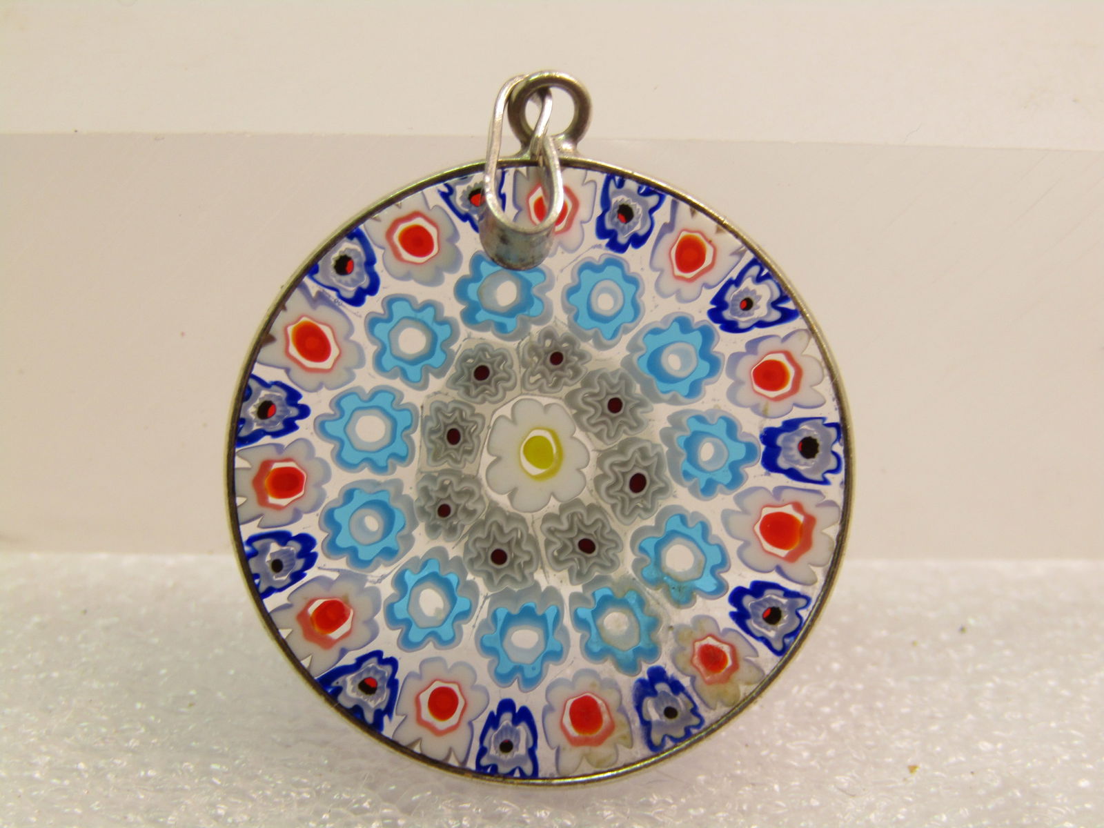 Sterling Silver Murano Milfiore Glass Pendant, 1990's 1.5", Signed: Sterling Silver Murano Milifiore Glass Pendant, 1990's 1.5", Signed. this has a floral motiff in concentric circles throughout the pendant in aqua, white, blue, and red with swing bail. It also