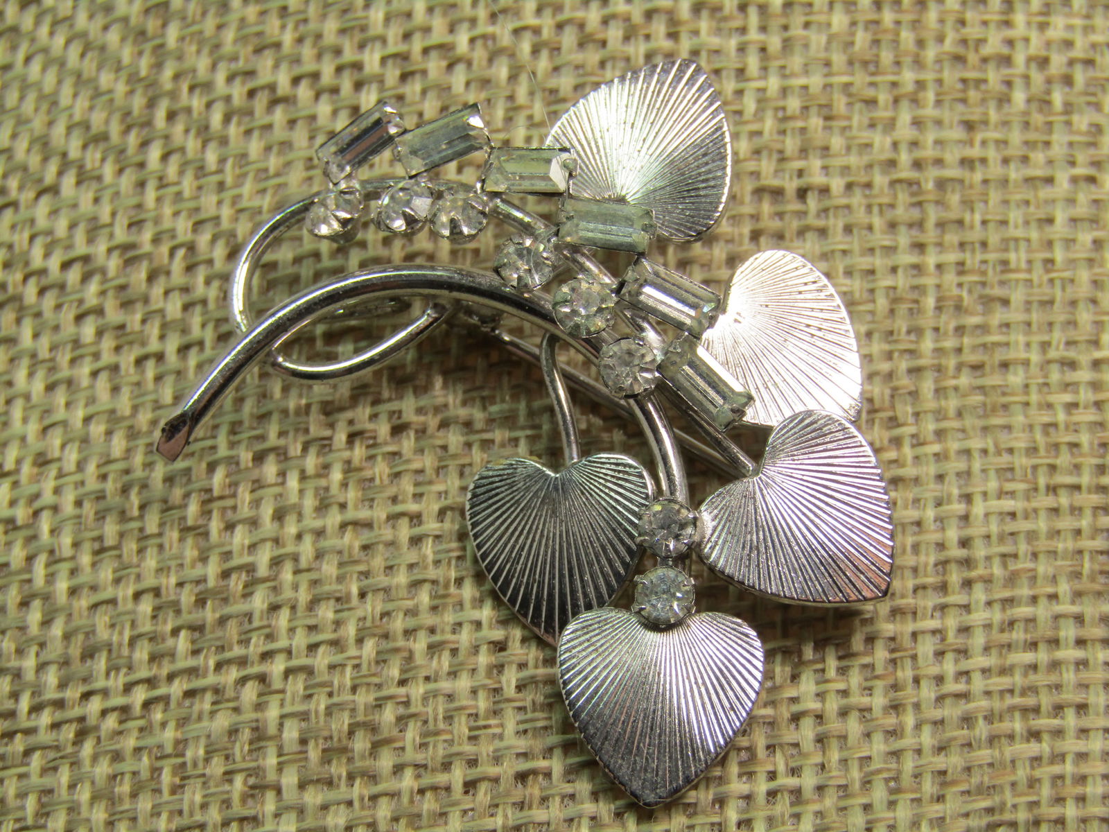 Vintage Sterling Rhinestone Leaf Brooch, Carl Art Signed, 1960's-1970's: Vintage Sterling Rhinestone Leaf Brooch, Carl Art Signed, 1960's-1970's. A branch with curved and looped stem with five heart-shaped ridged leaves with a stem of baguette and clear glass