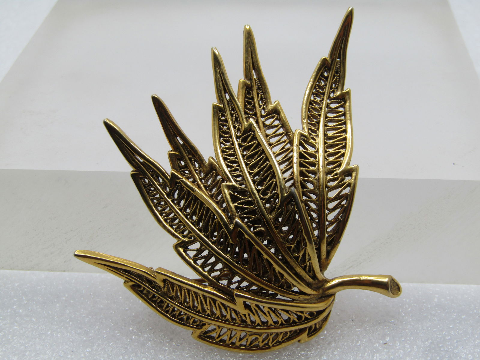 Vintage Leaf Cluster Brooch, 1960's, Gold Tone, Signed Avante: Vintage Leaf Cluster Brooch, 1960's, Gold Tone. Curved cluster of six long filigree jagged edged leaves tha are domed at the cenr and slope downward at the tips and stem. It is signed Avante. It