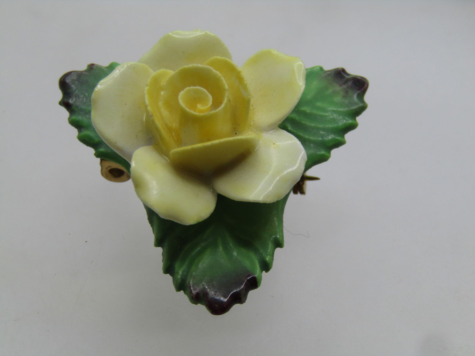 Vintage Painted Yellow Rose Porcelain Brooch, Signed Denton, England, 1960's: Vintage Painted Yellow Rose Porcelain Brooch, Signed Denton, England, 1960's. Slightly under 1.5" dow each side. Yellow rose with three green leaves that are in a triangular shape with the blossom