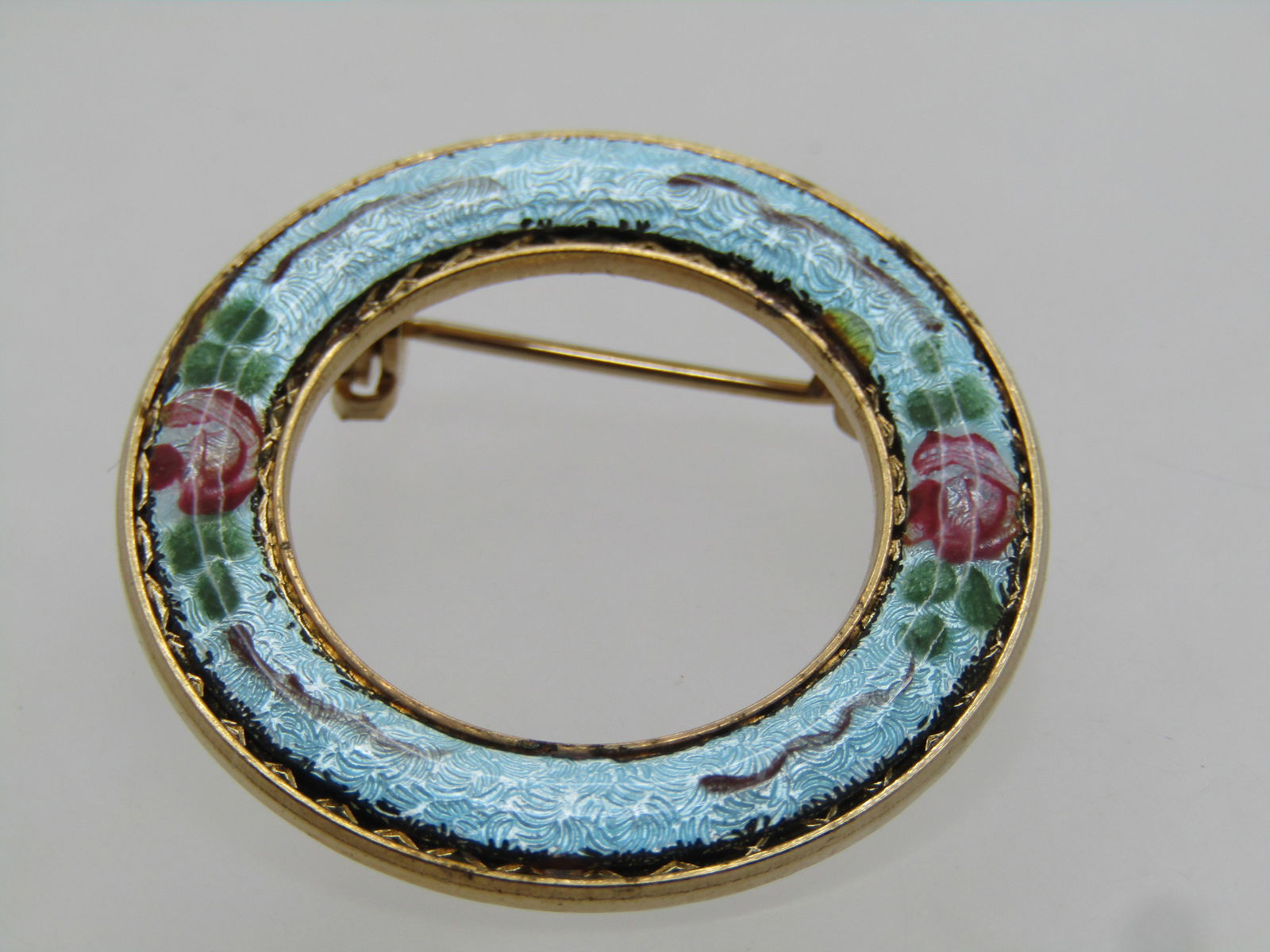 Vintage Floral Guilloche Circle Brooch, 1960's: Vintage Floral Guilloche Circle Brooch, 1960's. It is gold tone and appx. 1.25" across. Aqua blue with pink roses and brown vines. Slightly domed. Gold tone with locking clasp. It is not signed