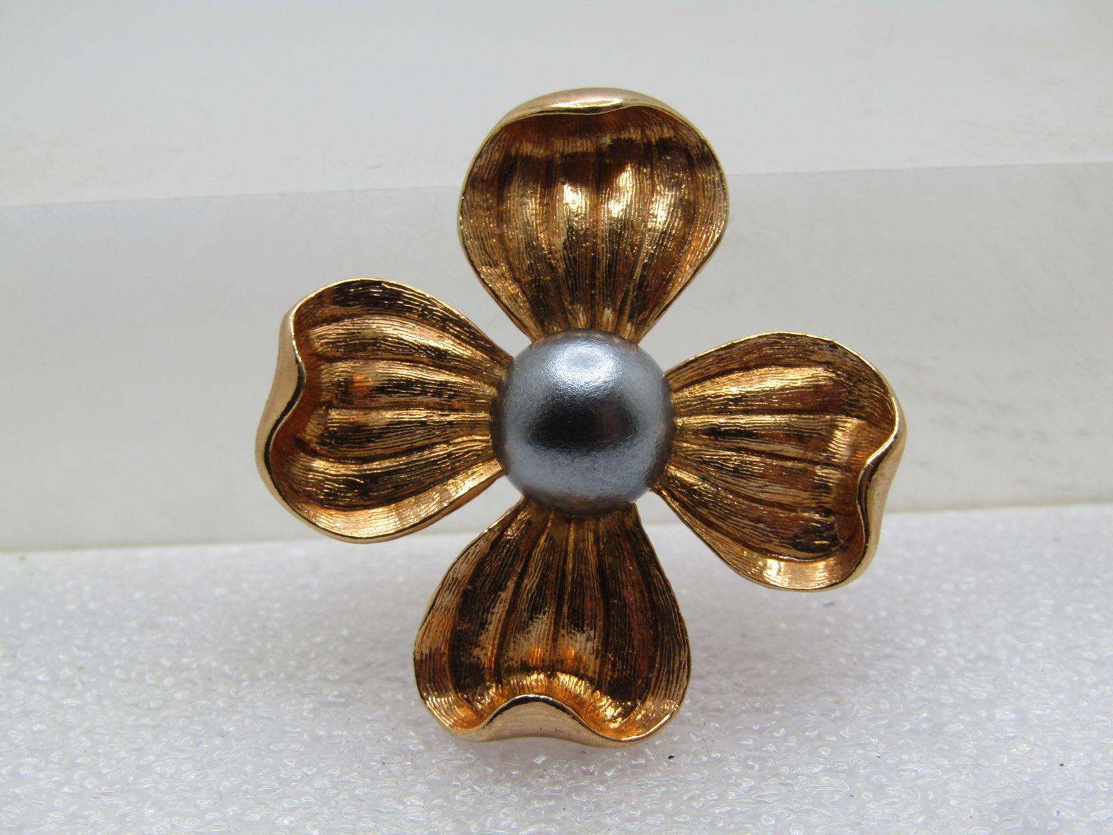 Vintage Gold Tone Dogwood Brooch/Pendant, 9mm Gray Pearl, 1960's-1970's: Vintage Gold Tone Dogwood Brooch/Pendant, 9mm Gray Pearl, 1960's-1970's. The blossom is appx. 1-3/8" wide with ridged and textured and peals with curved up tops. It has the locking clasp with a